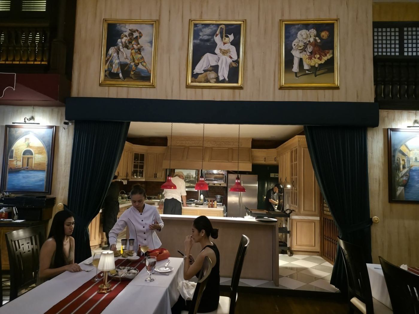 Commedia dell'Arte paintings above the open kitchen